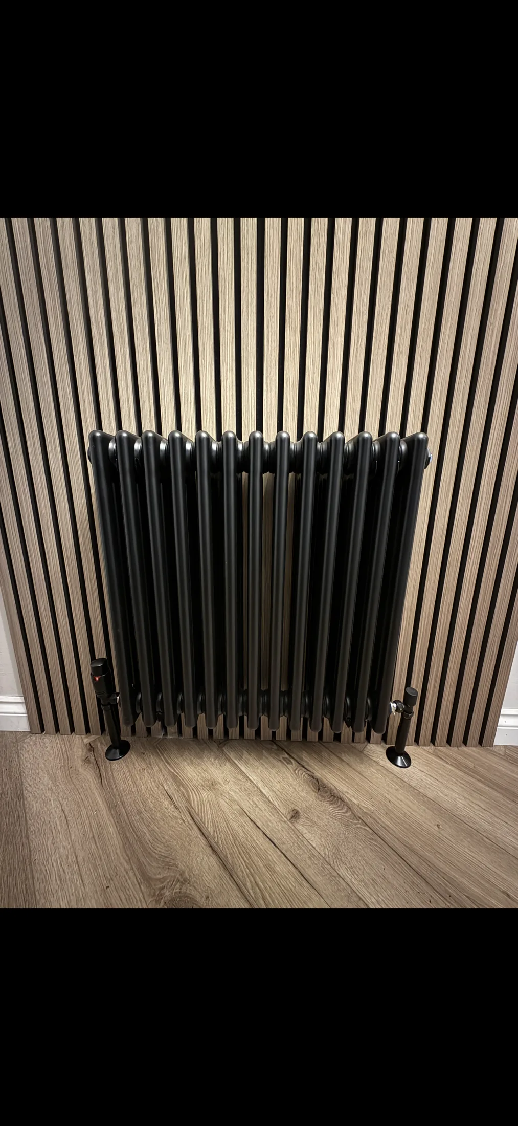 Tall vertical radiator on hallway wall